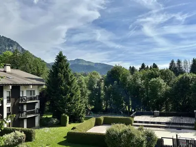 a view of a house with mountains in the background at Studio avec Piscine Chauffée, Tennis & Balcon - 4 Couchages à Megève - FR-1-597-14 in Megève