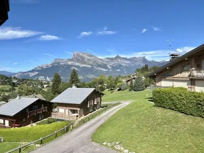 a road leading to a house with mountains in the background at Appartement Duplex 2 pièces, 4 couchages, proche pistes de ski, garage, Demi-Quartier - FR-1-597-16 in Demi-Quartier