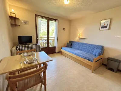 a living room with a blue couch and a table at Studio confortable avec balcon, proche des pistes - 2 couchages à Demi-Quartier - FR-1-597-18 in Demi-Quartier