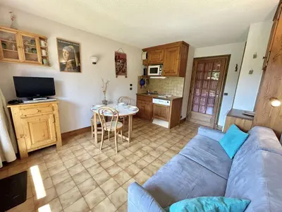 a living room with a blue couch and a kitchen at Studio Alcôve Cosy, 4 Pers, Jardin, Parking, Proche Télécabine et Golf - Megève - FR-1-597-21 in Megève