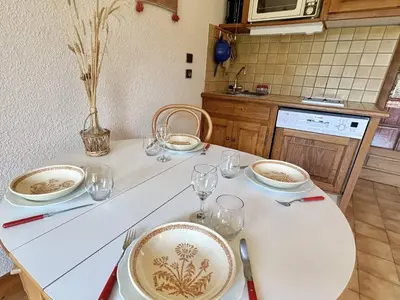 a kitchen with a table with plates and glasses on it at Studio Alcôve Cosy, 4 Pers, Jardin, Parking, Proche Télécabine et Golf - Megève - FR-1-597-21 in Megève