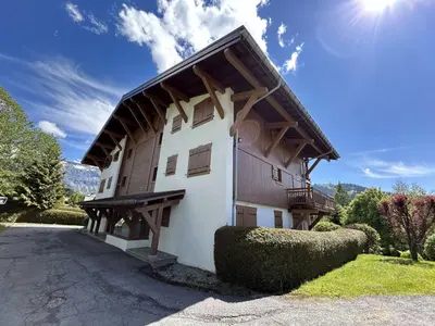 a large white building with a wooden roof at Studio Alcôve Cosy, 4 Pers, Jardin, Parking, Proche Télécabine et Golf - Megève - FR-1-597-21 in Megève