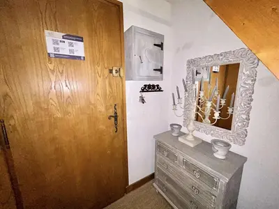 a room with a wooden door and a dresser with a mirror at Appartement cosy à Megève: 3 pièces + mezzanine, 4 couchages - Proche remontées mécaniques et golf - FR-1-597-19 in Megève