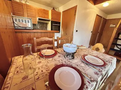 a kitchen with a table with plates and glasses on it at Appartement cosy à Megève: 3 pièces + mezzanine, 4 couchages - Proche remontées mécaniques et golf - FR-1-597-19 in Megève