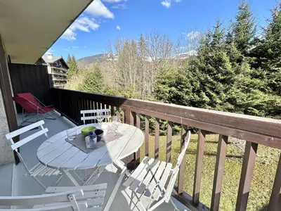 a balcony with a table and two chairs on a deck at Appartement cosy 2 pièces avec balcon, proche centre et télécabine, piscine et tennis en été - FR-1-597-20 in Megève