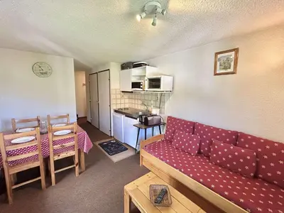a living room with a red couch and a kitchen at Charmant T2 à Demi-Quartier, 1 chambre, balcon, parking, casier à skis, proche forêt et espaces verts - FR-1-597-32 in Demi-Quartier