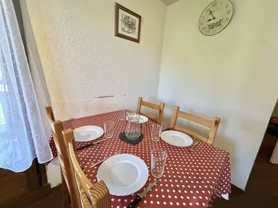 a living room with a couch and a table with a red table cloth at Charmant T2 à Demi-Quartier, 1 chambre, balcon, parking, casier à skis, proche forêt et espaces verts - FR-1-597-32 in Demi-Quartier