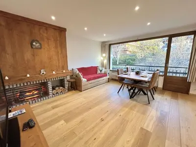 a living room with a table and a fireplace at Studios + Cabine à Megève, 4 Couchages, 500m des Remontées, Balcon Sud, Parking Inclus - FR-1-597-34 in Megève