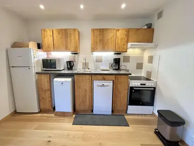 a small kitchen with white appliances and wooden cabinets at Studios + Cabine à Megève, 4 Couchages, 500m des Remontées, Balcon Sud, Parking Inclus - FR-1-597-34 in Megève