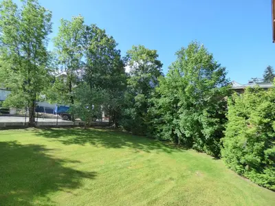 a large grassy yard with trees in the background at Studios + Cabine à Megève, 4 Couchages, 500m des Remontées, Balcon Sud, Parking Inclus - FR-1-597-34 in Megève