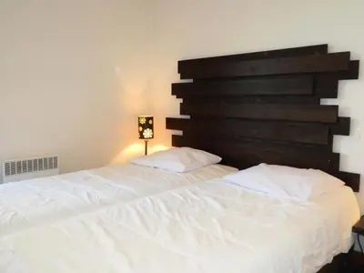 a bedroom with two white beds and a wooden headboard at Résidence Les Fermes De Saint Gervais - Fermes de Saint Gervais A4 MAE-5238 in Saint-Gervais-les-Bains