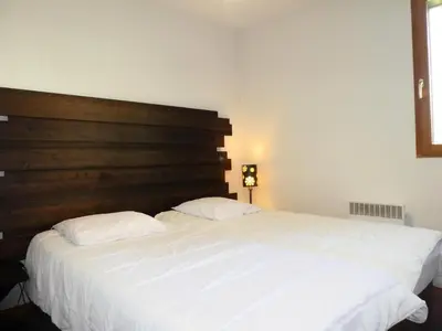 a bedroom with a large white bed with a wooden headboard at Résidence Les Fermes De Saint Gervais - Fermes de Saint Gervais A7 MAE-5287 in Saint-Gervais-les-Bains