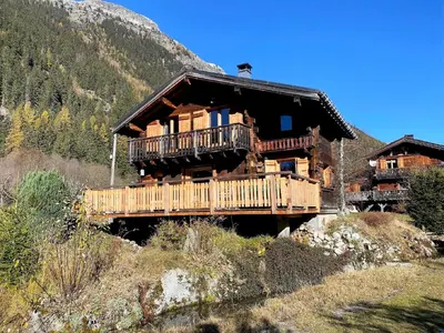 a large log cabin on a bridge in the mountains at Chalet Orval - Chamonix Argentière in Chamonix-Mont-Blanc