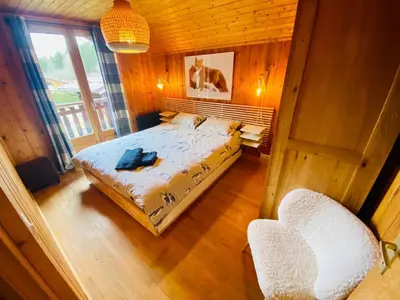 a bedroom with a bed and two chairs in it at Chalet Orval - Chamonix Argentière in Chamonix-Mont-Blanc