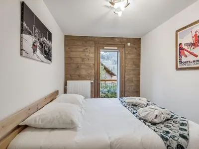a bedroom with a large white bed with a window at DIFY Appartement Luxe - Saint Gervais in Saint-Gervais-les-Bains