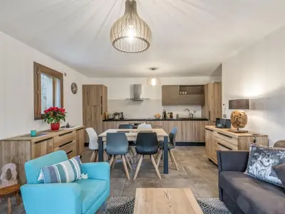 a living room with a table and chairs and a kitchen at DIFY Appartement Luxe - Saint Gervais in Saint-Gervais-les-Bains