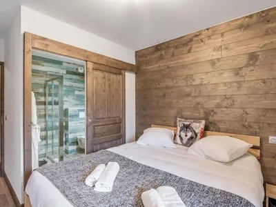 a bedroom with a bed with a wooden wall at DIFY Appartement Luxe - Saint Gervais in Saint-Gervais-les-Bains