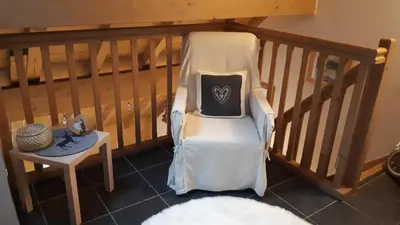 a white chair with a pillow on it next to a table at Duplex 6 pers, garage, WIFI, calme, proche des pistes, vue magnifique in Saint-Gervais-les-Bains