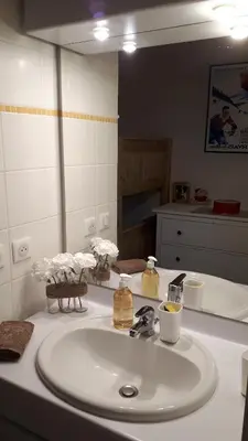 a bathroom with a white sink and a mirror at Duplex 6 pers, garage, WIFI, calme, proche des pistes, vue magnifique in Saint-Gervais-les-Bains