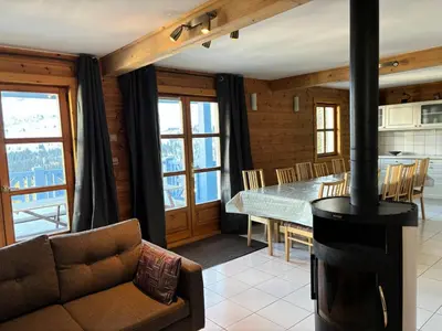 a living room with a wood stove and a table at Résidence Hameau - Chalet lumineux · Poêle à bois · Sauna · Garage MAE-7348 in Flaine