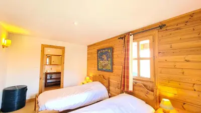 two beds in a room with wooden walls at Résidence Hameau - Chalet spacieux · Sauna · Cheminée MAE-7349 in Flaine