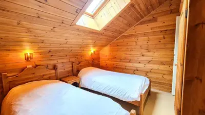 two beds in a log cabin with a skylight at Résidence Hameau - Chalet spacieux · Sauna · Cheminée MAE-7349 in Flaine