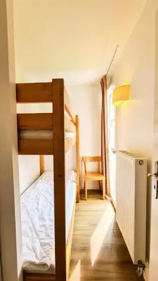 a bedroom with two bunk beds and a chair at Résidence Les Pleiades - Appartement lumineux et confortable · Centre station · Balcon · Parking couvert MAE-7351 in Flaine