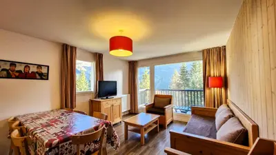 a bedroom with a bed and a television and a balcony at Résidence Les Pleiades - Appartement spacieux et lumineux · Centre station · Balcon · Parking couvert MAE-7354 in Flaine