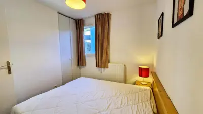 a bedroom with a white bed and a red lamp at Résidence Les Pleiades - Appartement spacieux et lumineux · Centre station · Balcon · Parking couvert MAE-7354 in Flaine