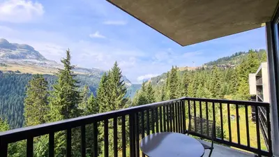 a room with a table and a dining room with a balcony at Résidence Les Pleiades - Appartement spacieux et lumineux · Centre station · Balcon · Parking couvert MAE-7355 in Flaine