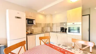 a kitchen and dining room with a table and chairs at Résidence Les Pleiades - Appartement spacieux et lumineux · Centre station · Balcon · Parking couvert MAE-7355 in Flaine