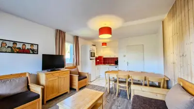 a living room with a table and a kitchen at Résidence Les Pleiades - Appartement spacieux · Centre station · Balcon · Parking couvert MAE-7356 in Flaine