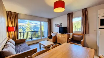 a living room with a table and a large window at Résidence Les Pleiades - Appartement spacieux · Centre station · Balcon · Parking couvert MAE-7356 in Flaine