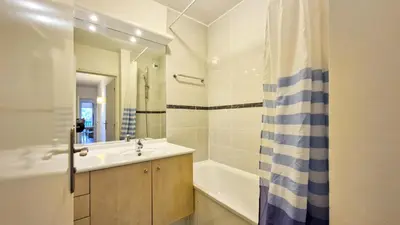 a bathroom with a sink and a tub and a mirror at Résidence Les Pleiades - Appartement spacieux · Centre station · Balcon · Parking couvert MAE-7356 in Flaine