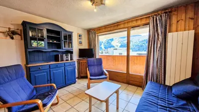 a living room with blue chairs and a window at Résidence Arche - Appartement spacieux · Centre station · Balcon MAE-7358 in Flaine