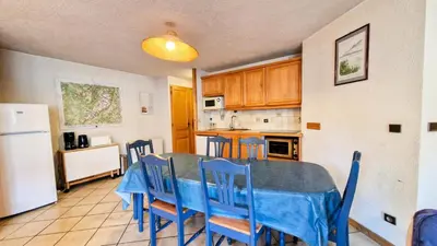 a kitchen with a table and chairs and a refrigerator at Résidence Arche - Appartement spacieux · Centre station · Balcon MAE-7358 in Flaine