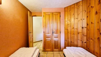 two beds in a room with wooden walls at Résidence Arche - Appartement spacieux · Centre station · Balcon MAE-7358 in Flaine