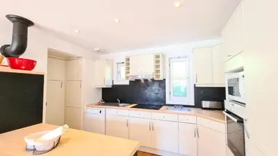 a kitchen with white cabinets and a wooden table at Résidence Hameau - Chalet spacieux · Poêle à bois · WIFI gratuit et illimité · Garage MAE-7359 in Flaine