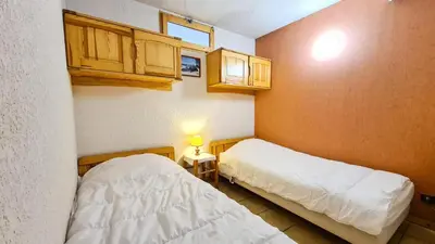 a small room with two beds and a table with a lamp at Résidence Arche - Appartement confortable · Centre station · Terrasse MAE-7360 in Flaine