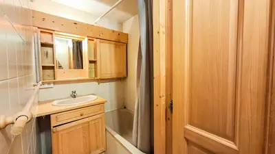 a small bathroom with a sink and a mirror at Résidence Arche - Appartement confortable · Centre station · Terrasse MAE-7360 in Flaine