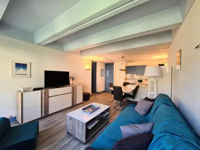 a living room with a blue couch and a table at Résidence Betelgeuse - Appartement rénové · Proche des pistes et des commerces · Balcon MAE-7361 in Flaine