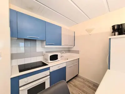 a kitchen with blue cabinets and a microwave at Résidence Betelgeuse - Appartement rénové · Proche des pistes et des commerces · Balcon MAE-7361 in Flaine