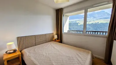 a bedroom with a bed and a large window at Résidence Les Pleiades - Appartement confortable · Centre station · Balcon MAE-7365 in Flaine