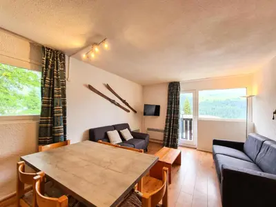 a living room with a table and a couch at Résidence Gemeaux - Appartement confortable · Centre station · Balcon MAE-7369 in Flaine