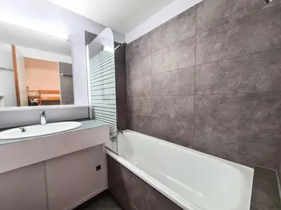 a bathroom with a sink and a tub and a mirror at Résidence Gemeaux - Appartement confortable · Centre station · Balcon MAE-7369 in Flaine