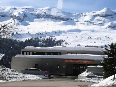 a building in front of a snow covered mountain at Résidence Les Pleiades - Appartement lumineux · Centre station · Balcon · Parking couvert MAE-7373 in Flaine