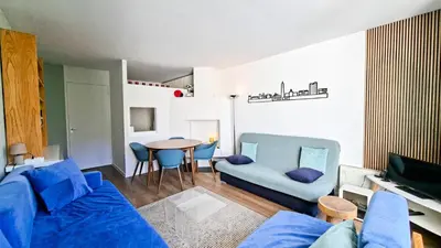 a living room with a blue couch and a table at Résidence Belier - Appartement confortable · Au pied des pistes · WIFI gratuit et illimité · Terrasse MAE-7374 in Flaine