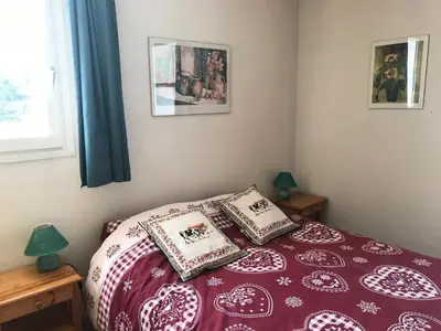 a bedroom with a red and white bed with two pillows at Résidence Chateaux De Crans - Appartement confortable · Balcon MAE-7375 in Flaine