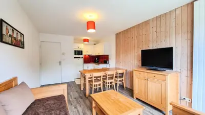a living room with a television and a table with chairs at Résidence Les Pleiades - Appartement spacieux · Centre station · Parking couvert · Balcon MAE-7381 in Flaine