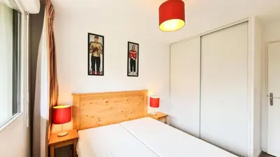 a bedroom with a bed and two pictures on the wall at Résidence Les Pleiades - Appartement spacieux · Centre station · Parking couvert · Balcon MAE-7381 in Flaine